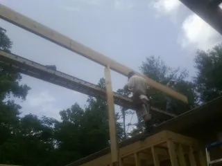Carpenter setting a ridge beam over a new addition frame — Ice Dam Removal by Roofing Brothers in Colmar