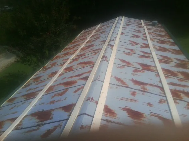 Rusted metal roof panels with new wood purlins before replacement — Storm Damage Roof Repair in Colmar by Roofing Brothers