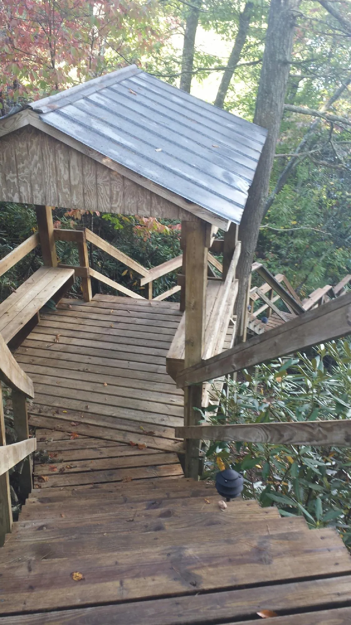 Metal roofed shelter over wooden steps on a wooded walkway — Skylight Repair & Installation work by our crew in Colmar