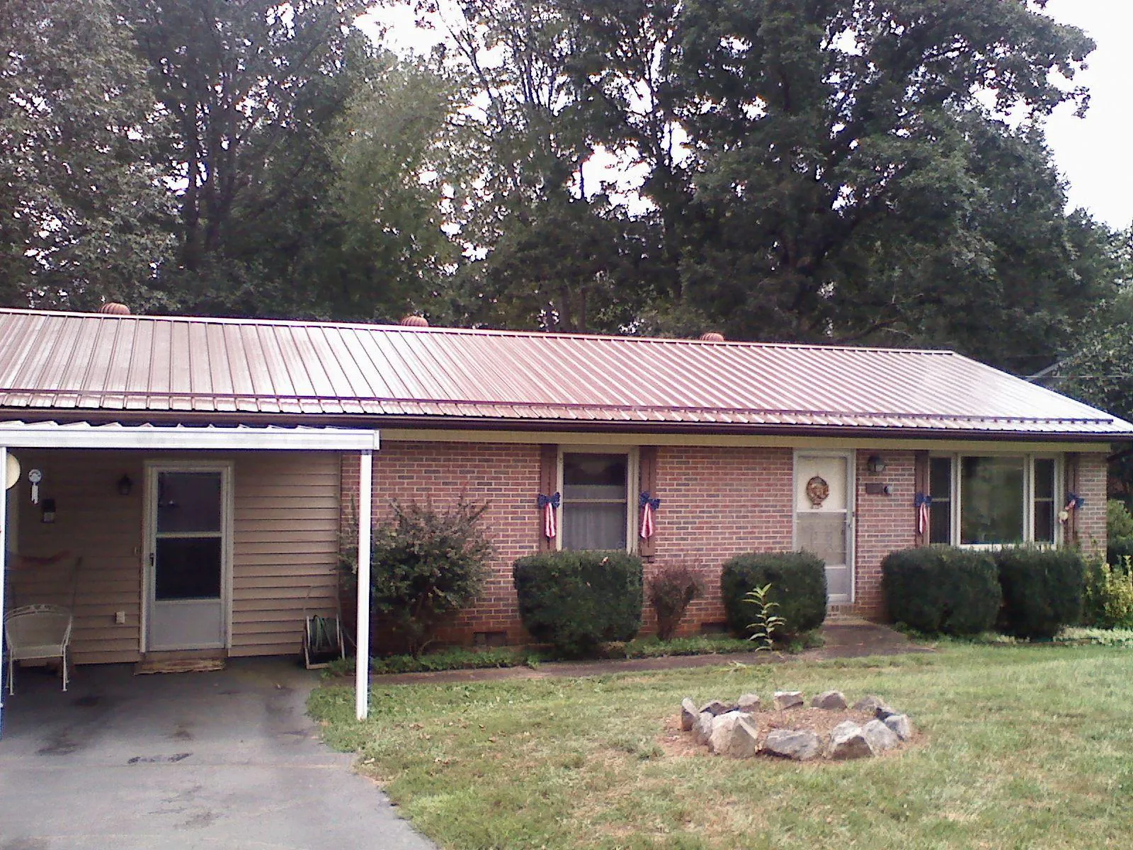 Bronze metal roof and carport on a brick ranch home — Roof Repair work by our crew in Colmar